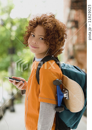 Mixed Race boy listening to mp3 player 11629025