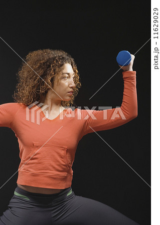 Mixed Race woman holding dumbbell Mixed Race woman holding dumbbell 11629029