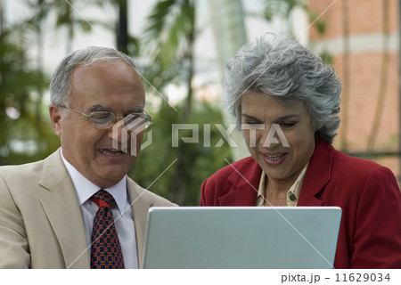 Senior Hispanic couple looking at laptop 11629034