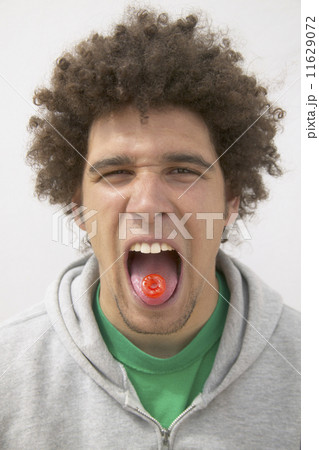 Young man with lifesaver on tongue 11629072