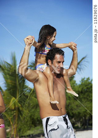 Hispanic father carrying daughter on shoulders 11629076