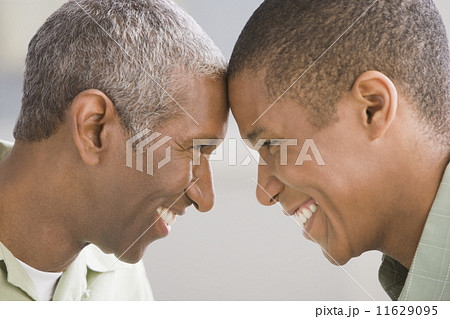 African American father and adult son touching foreheads African American father and adult son touching foreheads 11629095