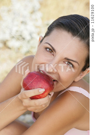 Young woman biting apple 11629100