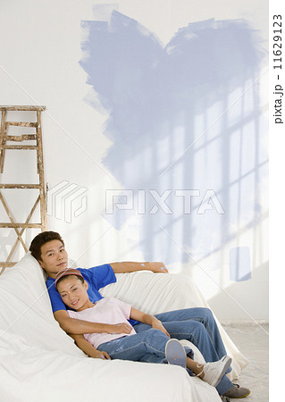 Asian couple in partially painted room 11629123