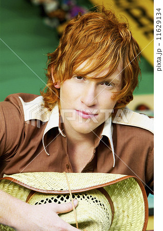 Close up of male teenager with straw hat Close up of male teenager with straw hat 11629134