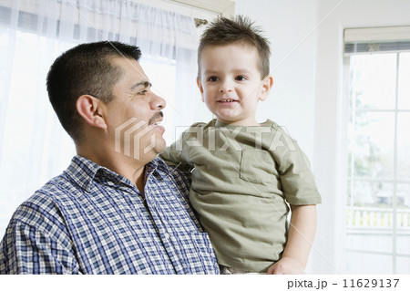 Hispanic father and son hugging 11629137