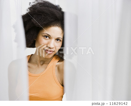African American woman through parted curtains 11629142