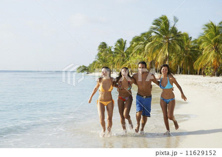 South American friends running at beach 11629152