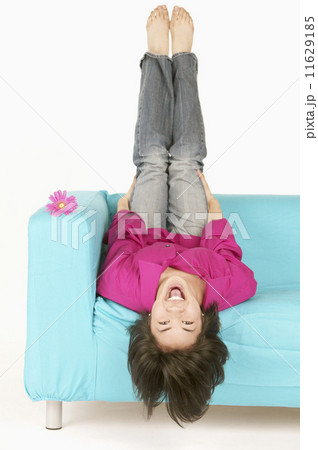 Portrait of woman sitting upside down in chair 11629185