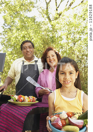 Hispanic family using barbecue grill  11629188