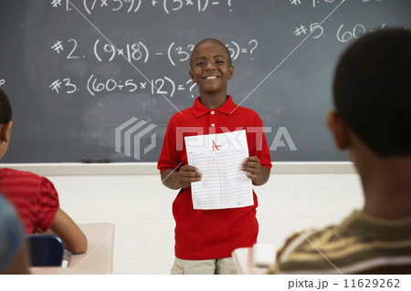 African American boy holding paper in front of class African American boy holding paper in front of class 11629262