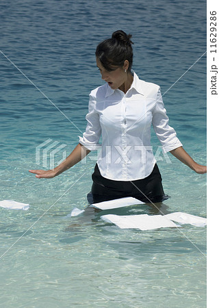 Hispanic businesswoman with papers in water 11629286