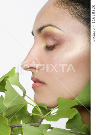 Indian woman's face next to gingko biloba plant 11629320