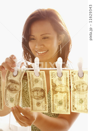 Asian woman hanging money on clothes line 11629343