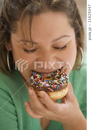 Young woman eating a donut Young woman eating a donut 11629347