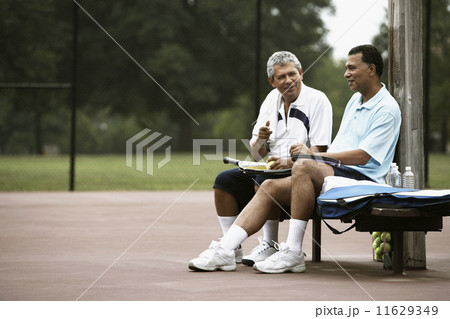Multi-ethnic men talking on tennis court Multi-ethnic men talking on tennis court 11629349