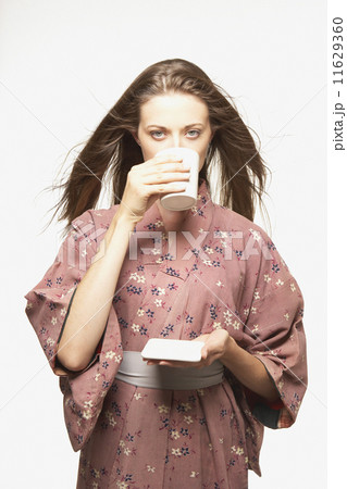 Portrait of woman wearing kimono drinking tea Portrait of woman wearing kimono drinking tea 11629360