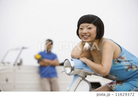 Asian woman sitting on motor scooter 11629372