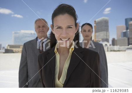 Businesswoman with co-workers in urban background Businesswoman with co-workers in urban background 11629385