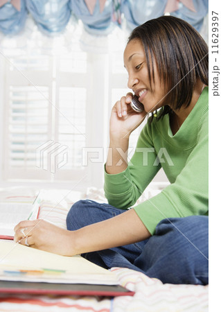 Girl in bedroom using mobile phone 11629397