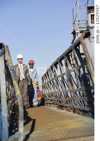 Multi-ethnic businessman and construction worker walking Multi-ethnic businessman and construction worker walking 11629567