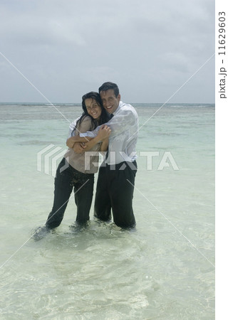 Hispanic businesspeople hugging in water 11629603