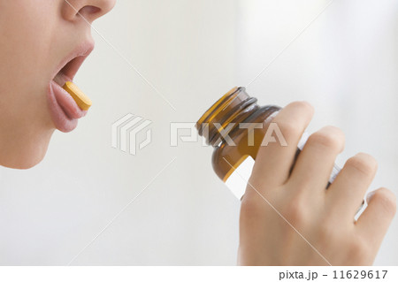 Woman with vitamin on tongue 11629617