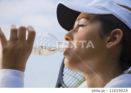 Hispanic woman drinking from water bottle 11629628