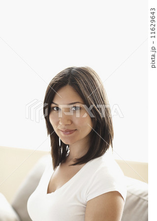 Mixed Race woman sitting on sofa 11629643