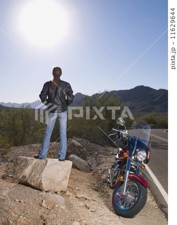 Hispanic woman standing next to motorcycle 11629644