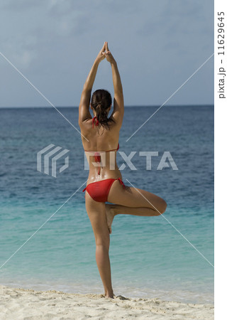 Young woman practicing yoga at beach Young woman practicing yoga at beach 11629645