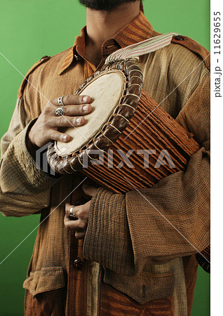 Midsection of man with drum Midsection of man with drum 11629655