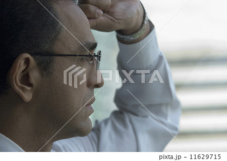 Hispanic businessman looking out window 11629715