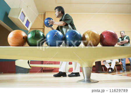 Side view of man with bowling balls Side view of man with bowling balls 11629789