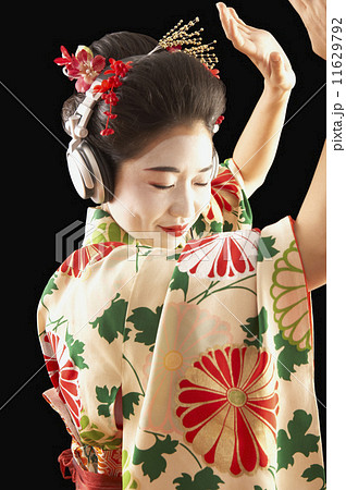 Asian woman in ethnic clothes listening to headphones 11629792