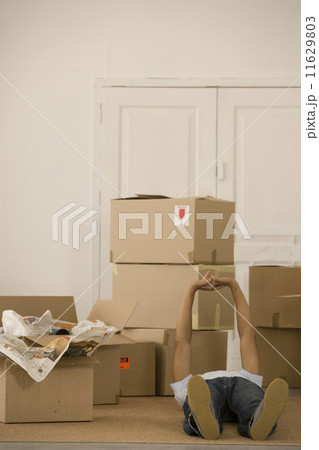 Man laying on floor next to moving boxes 11629803