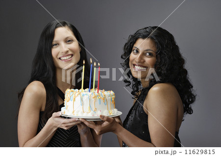 Portrait of women holding birthday cake 11629815