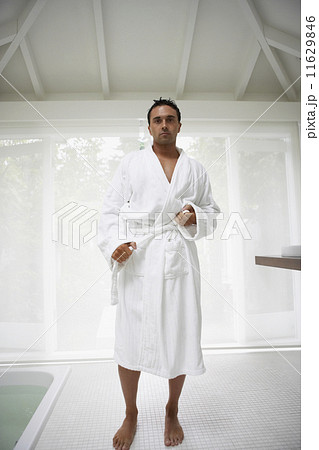 Man tying bathrobe in bathroom 11629846
