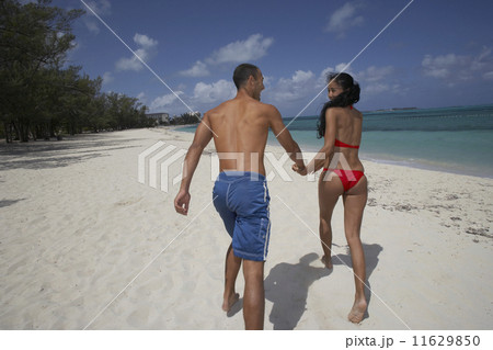 Hispanic couple running on beach 11629850