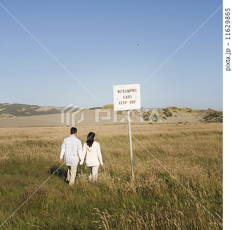 Multi-ethnic couple walking in field Multi-ethnic couple walking in field 11629865