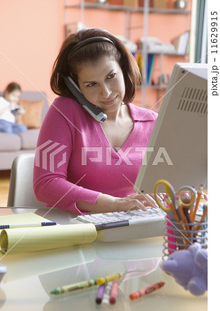 Mother on phone and computer while working from home 11629915