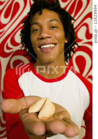 African man holding fortune cookie 11629994
