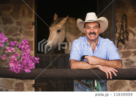 Hispanic man in front of stable Hispanic man in front of stable 11630009