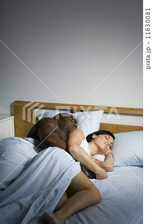 Multi-ethnic couple sleeping in bed 11630081