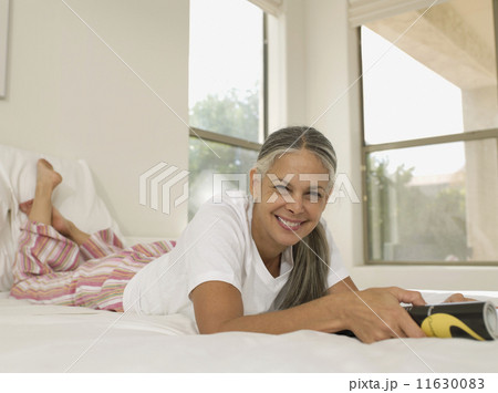 Asian woman reading on bed 11630083