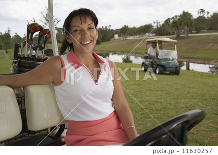 Hispanic woman sitting in golf cart 11630257