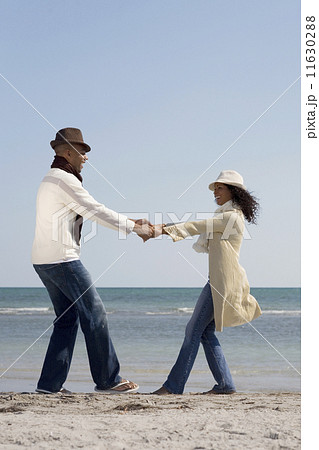 Multi-ethnic couple dancing at beach Multi-ethnic couple dancing at beach 11630288