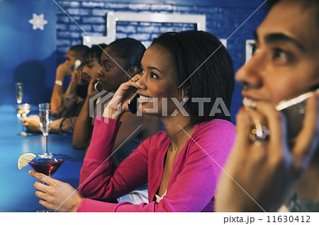 Group of people talking on cell phones at bar 11630412