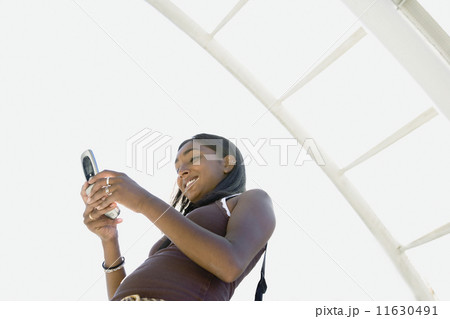 Low angle view of Indian woman dialing cell phone Low angle view of Indian woman dialing cell phone 11630491