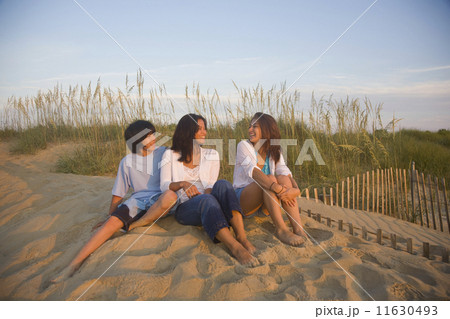 Asian woman and children sitting on beach Asian woman and children sitting on beach 11630493